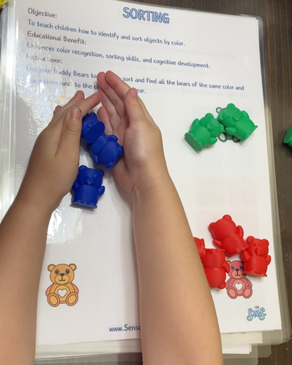 Toddler sorting Buddy Bears by color on activity sheet to enhance color recognition and sorting skills.