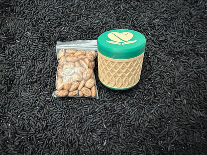 May include: A clear plastic bag filled with pinto beans next to a green and tan container with a coffee bean design on the lid. The objects are on a bed of black rice.