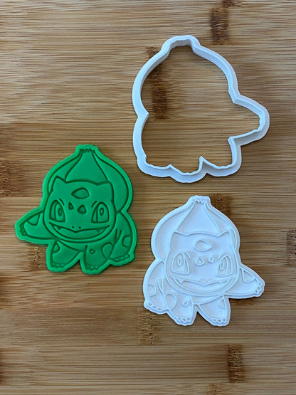 May include: Green and white plastic cookie cutters shaped like a cartoon character. The character has a large head, big eyes, and a wide mouth. The cutters are used to make cookies in the shape of the character.