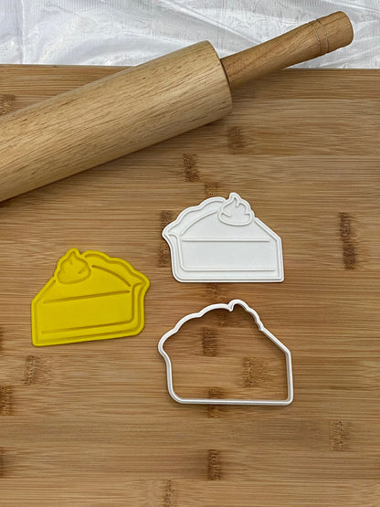 May include: Two white plastic pie slice cookie cutters and one yellow plastic pie slice cookie cutter on a wooden cutting board with a wooden rolling pin.